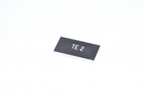 Merkkikilpi, musta, 37x19mm suorakulmainen, "TE 2"