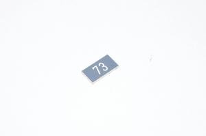 Merkkikilpi, harmaa, 20x11mm suorakulmainen, "73"